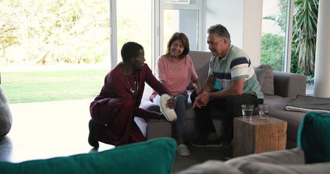 Healthcare Professional Assisting Senior Couple in Home Rehabilitation