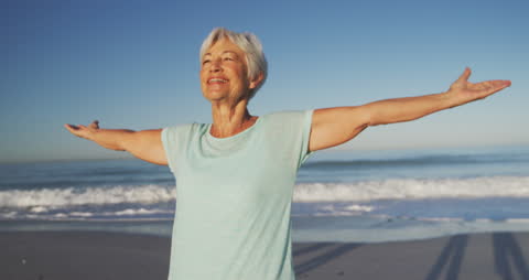 Joyful Senior Woman Embracing Freedom on Sunny Beach
