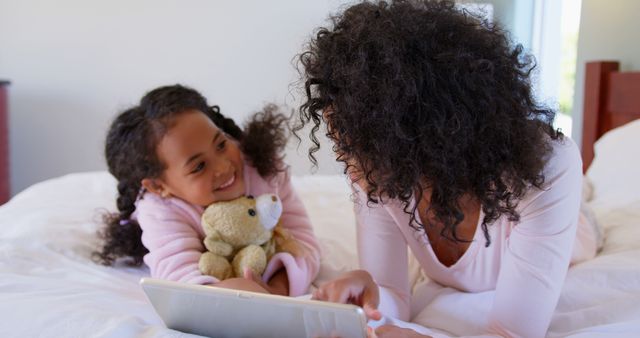 Mother and Daughter Enjoying Digital Tablet on Bed - Download Free Stock Images Pikwizard.com