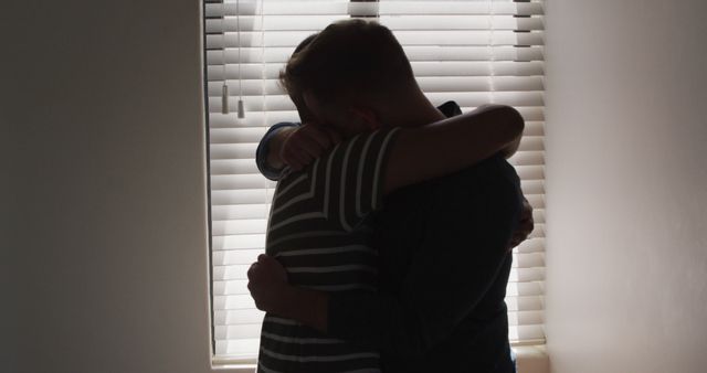 Comforting Hug Between Two People Near Window With Blinds - Download Free Stock Images Pikwizard.com