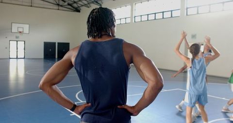 Basketball Coach Observing Players in Training Session