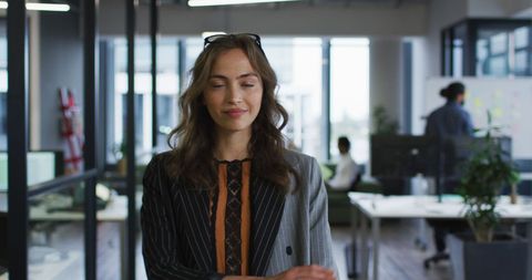 Confident Businesswoman Standing with Arms Crossed in Modern Office