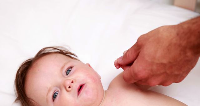 Parent Comforting Baby Lying on Bed - Download Free Stock Images Pikwizard.com