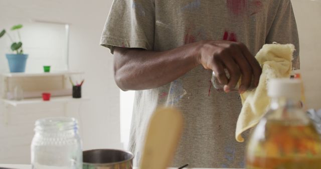 Mid section of african american male artist cleaning his hands at art studio. art, hobby and creative occupation concept