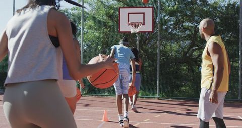Diverse Female Basketball Team Training with Coach on Outdoor Court