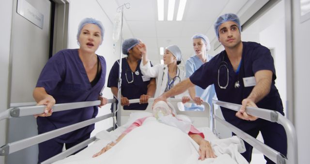Scene shows a team of medical professionals in scrubs and surgical caps, urgently transporting a patient on a hospital gurney down a hallway. This conveys urgency, teamwork, and healthcare in action. Useful for depicting emergency medical care, hospital environments, or teamwork in healthcare settings.