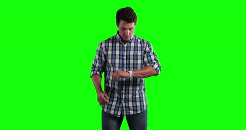 Man Checking Smartwatch Against Green Background