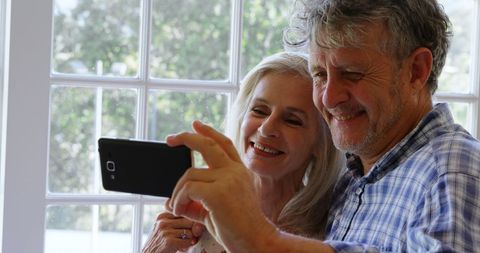 Senior Couple Joyfully Taking Selfie at Home