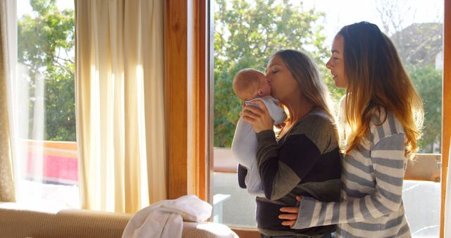 Happy Same-Sex Couple with Baby Enjoying Morning Sunlight - Download Free Stock Images Pikwizard.com