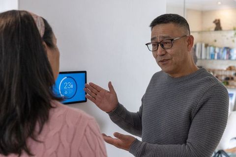 Couple Discussing Smart Thermostat Settings at Home