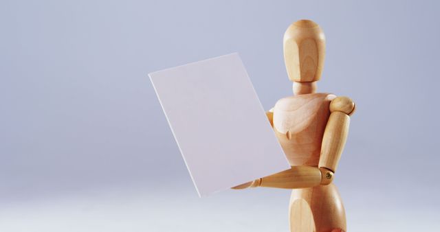 Wooden Art Mannequin Holding Blank Sheet of Paper on Purple Background - Download Free Stock Images Pikwizard.com