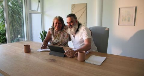 Senior Couple Engaging with Tablet Technology at Home for Financial Planning