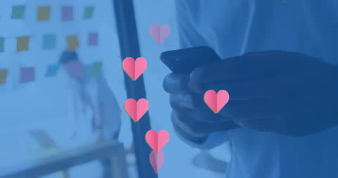 Animated Hearts Over Man Using Smartphone in Office Setting