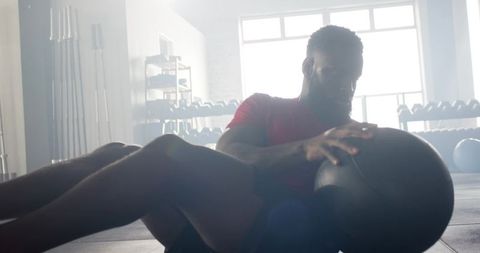 Man Exercising Core with Medicine Ball in Gym Workout