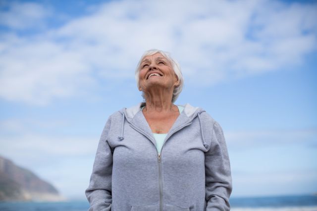 Smiling Senior Woman Enjoying Fresh Air on Beach - Download Free Stock Photos Pikwizard.com