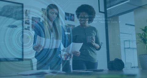 Collaborating women reviewing design layouts in modern open office with ar interface