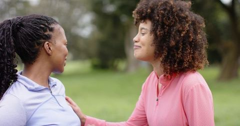 Diverse women sharing supportive moment outdoors during walk and conversation