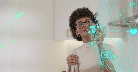 Smiling woman talking on smartphone in modern kitchen with turquoise connectivity overlay