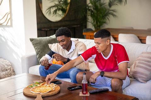 Diverse Friends Sharing Pizza in Cozy Living Room