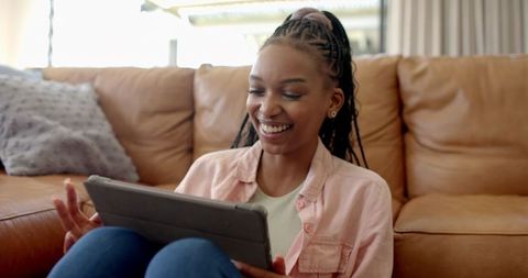 Smiling young woman relaxing at home with tablet