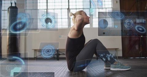 Female athlete performing sit-ups with futuristic HUD overlays in industrial gym studio