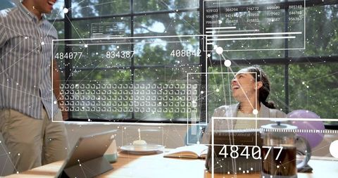 Laughing coworker celebrating at sunlit modern office desk with holographic data overlay