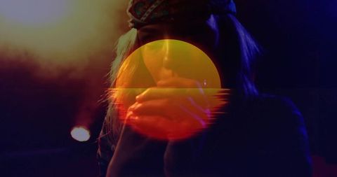 Performer holding hands near mouth with retro sun overlay and moody stage lighting