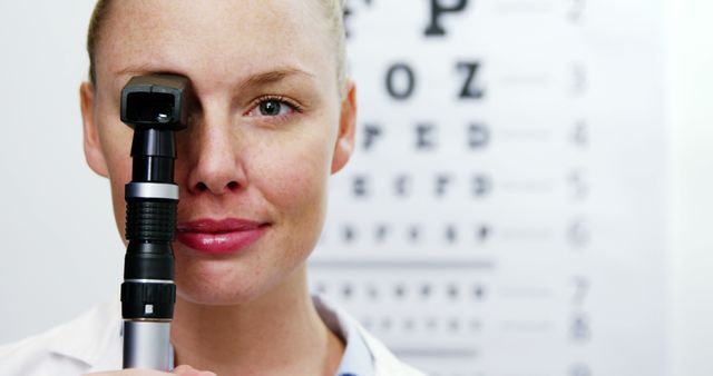 Smiling Optometrist Holding Ophthalmoscope in Eye Clinic - Download Free Stock Images Pikwizard.com