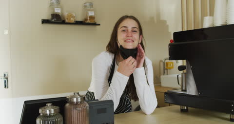 Smiling Waitress in Cafe Removing Face Mask