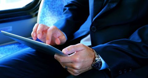 Businessman Using Digital Tablet on Train Journey