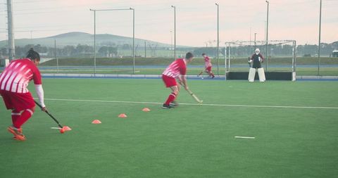 Field hockey players practicing with intense focus on strategy