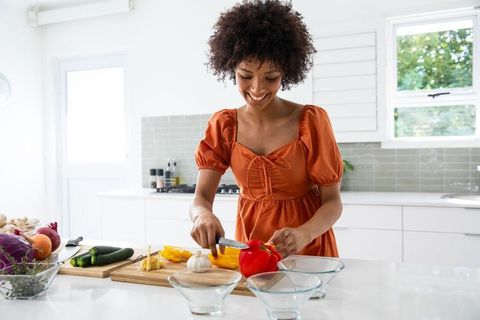 African American Woman Preparing Fresh Peppers in Modern Kitchen