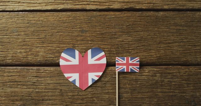 Image of flags of great britain in shape of heart and rectangle on wooden background. nationality, state symbols, patriotism and independence concept.