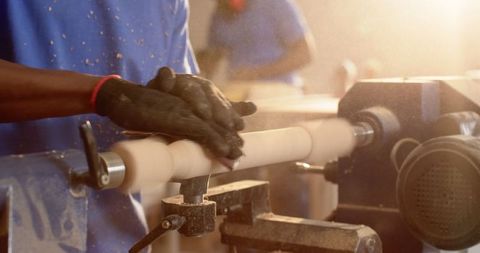 Artisans crafting wood with lathe in workshop sunlight