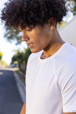 Energetic African American Man in White Mesh Shirt Resting During Urban Workout