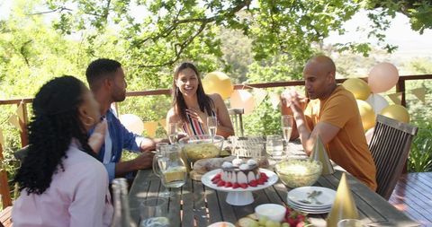 Joyful Friends Celebrating Outdoor Birthday Party with Gifts and Snacks