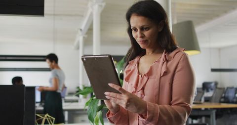 Businesswoman Smiling While Using Tablet in Modern Office - Download Free Stock Images Pikwizard.com