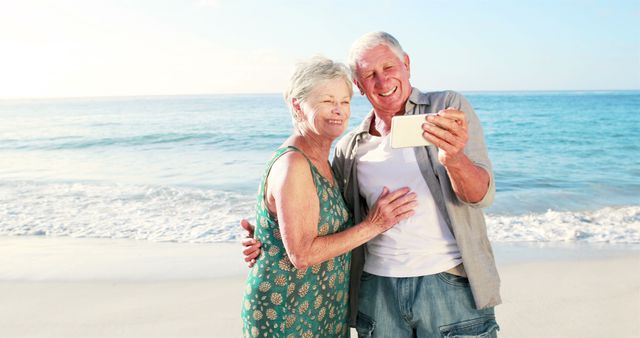 Senior couple enjoying their vacation by taking a selfie on a scenic beach during sunset. The image emphasizes togetherness and happiness, capturing tender moments. Perfect for advertisements and articles focusing on senior travel, retirement lifestyle, happy relationships, and vacation destinations.