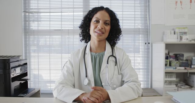 Smiling Female Doctor Sitting at Desk in Office - Download Free Stock Images Pikwizard.com