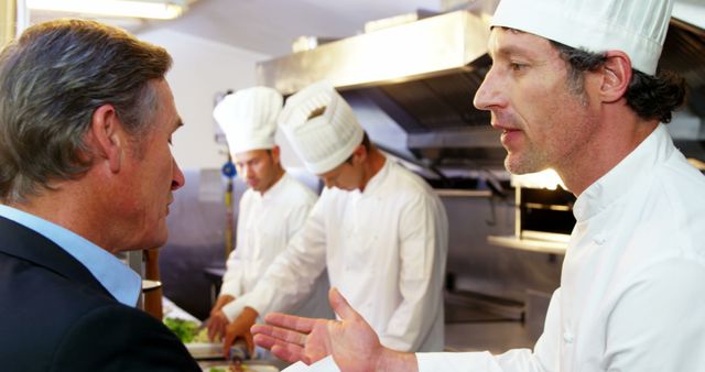 Chef Discussing With Manager In Busy Restaurant Kitchen - Download Free Stock Images Pikwizard.com