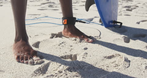 Surfer Standing on Sand with Board on Sunny Beach