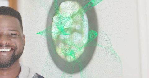 Smiling man wearing gray hoodie at home with green digital mesh overlay and round mirror