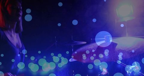 Wet crash cymbal splashing under neon lights, drummer performing with moody bokeh and haze