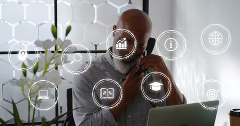 Executive talking on corded handset, working at desk with virtual business interface