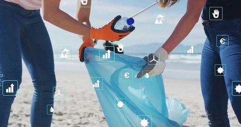 Volunteers collecting litter on sunlit beach promoting conservation