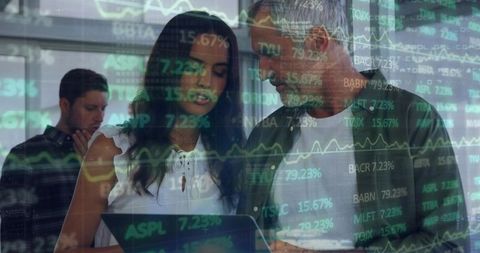 Business team reviewing laptop with stock market data overlay for financial collaboration