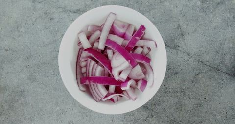 Freshly Sliced Red Onions in White Bowl on Grey Countertop