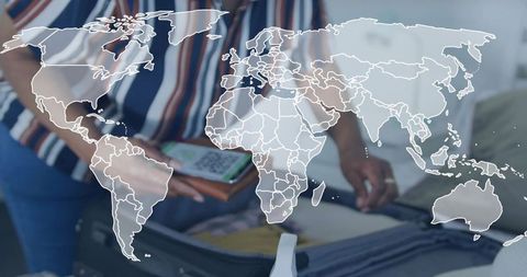 Senior woman packing suitcase displaying smartphone qr code with world map overlay