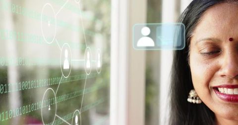 Smiling mature indian woman gazing at window with binary network overlay, bindi and jhumka