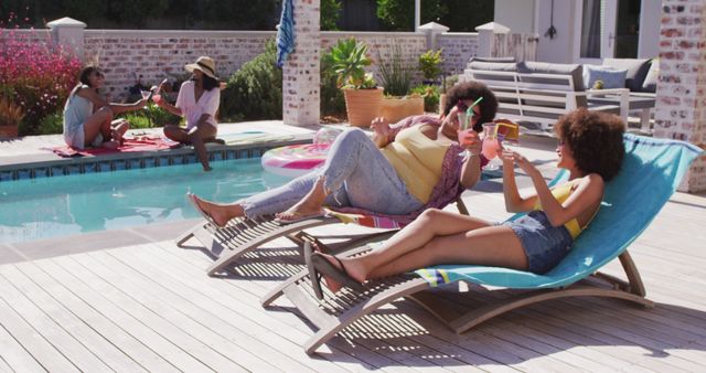 Shows group of friends enjoying a sunny day by the pool. Ideal for concepts of summer leisure, vacation, outdoor activities, and lifestyle content. Great for articles or content about relaxation, socializing, and spending time with loved ones.